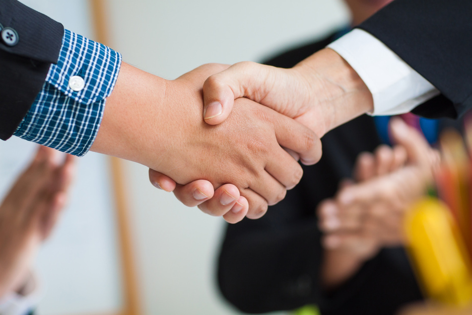 Business people shake hands after mediation.